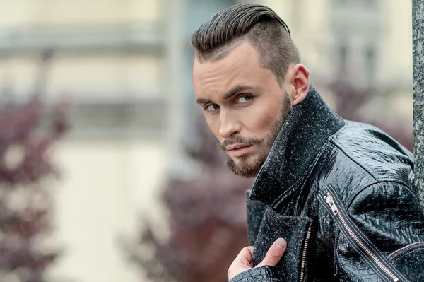 Man on the street in a leather coat.