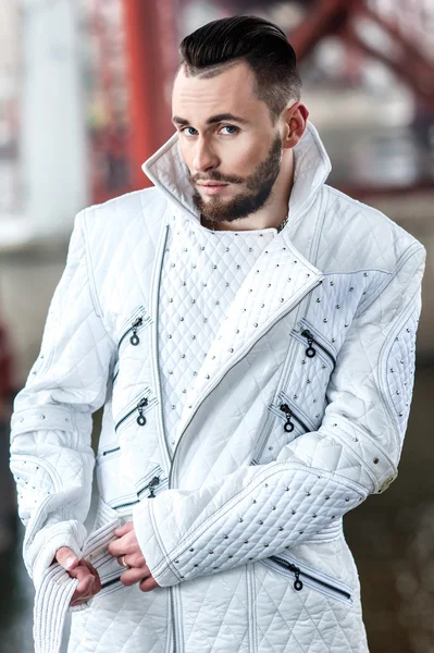 Stylish man with a beard in a white leather coat
