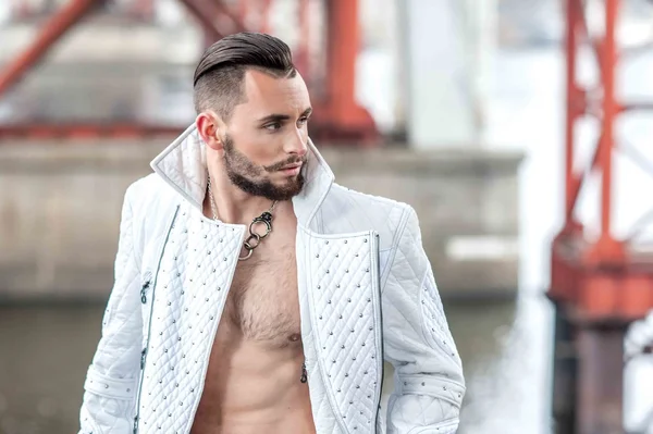 Stylish man with a beard in a white leather coat