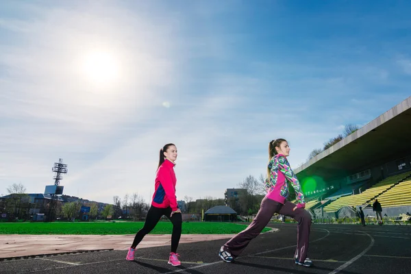 Women  stretching together  at the stadium