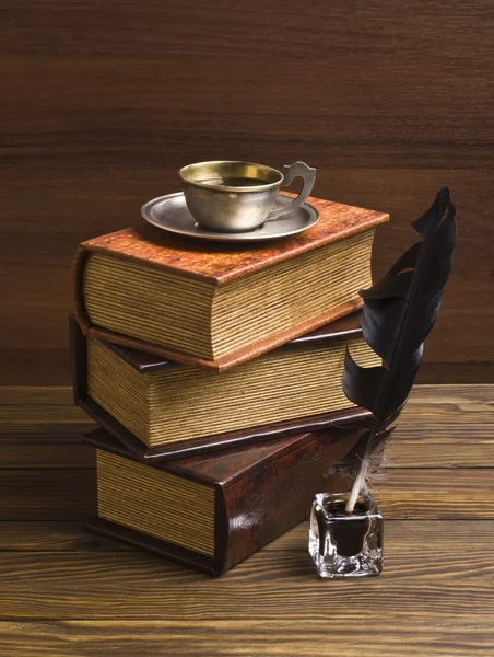 Old books and pen on a wooden table