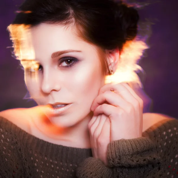 Soft focus of Beautiful brunette woman with evening make up. Freezelight effect on a photo
