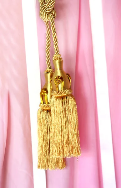 Close up gold color elegance curtain tassel in luxury house