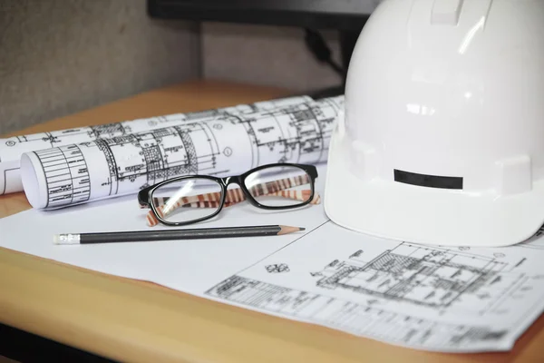 File of safety helmet and architect plant on wood table