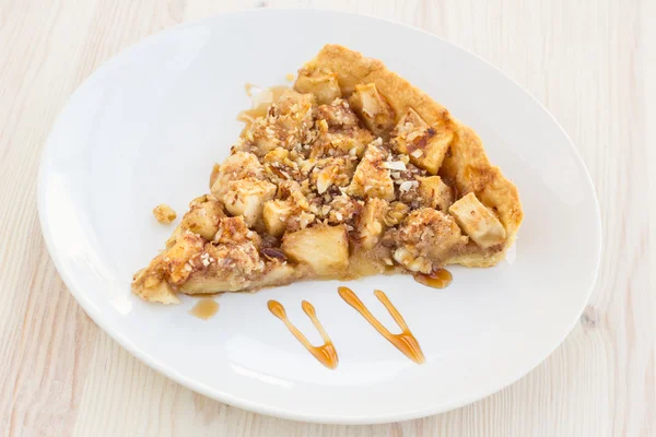 Slice of delicious fresh baked apple pie on a wooden surface