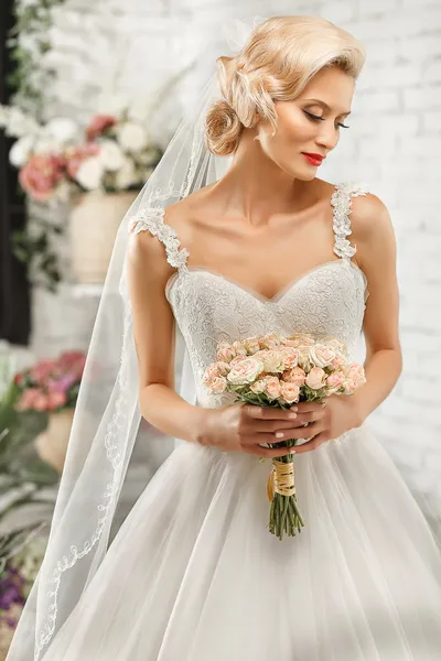 The beautiful woman posing in a wedding dress