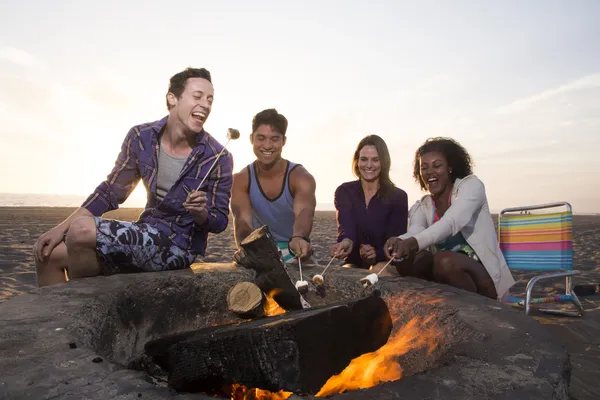 Two Young Couples Around a Fire on the Beach