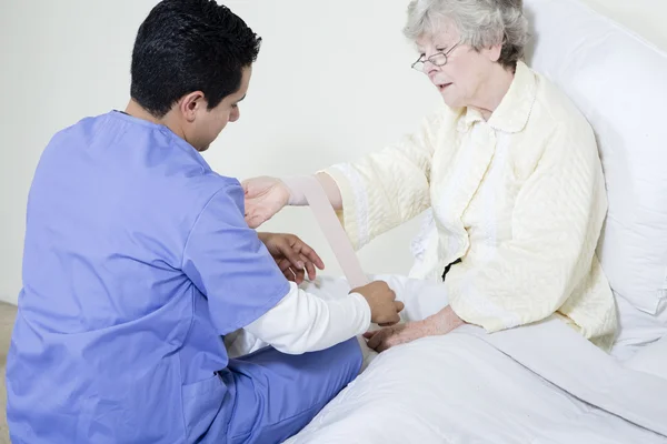 Male Nurse Assisting an Elderly Patient