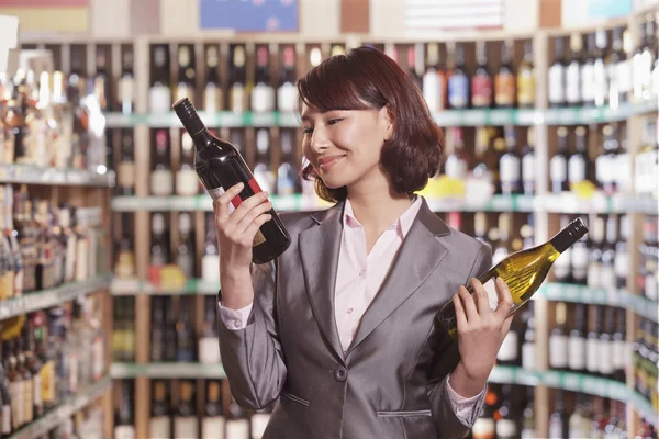 Mid Adult Woman Choosing Wine in a Liquor Store — Stock Photo #36080791