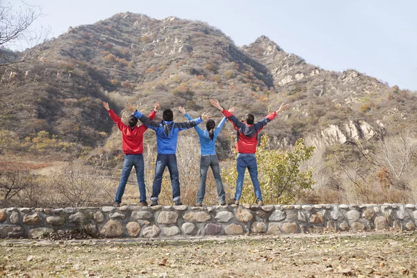 People standing on the ledge, arms outstretched