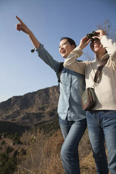 Women hiking, pointing at the mountain top