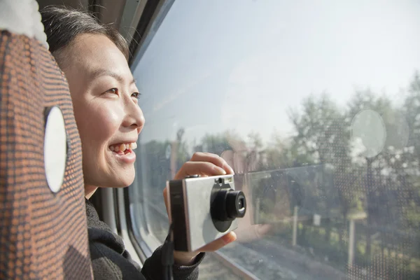 Woman Taking Photographs Outside Train Window