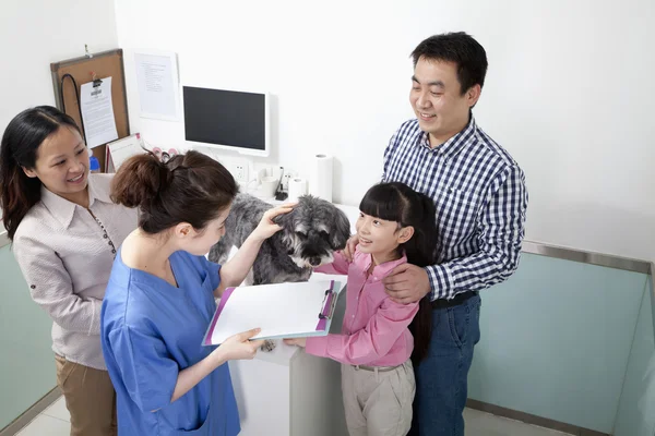 Family with pet dog in veterinarian\'s office
