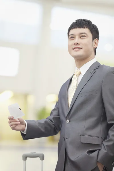 Business man holding flight ticket