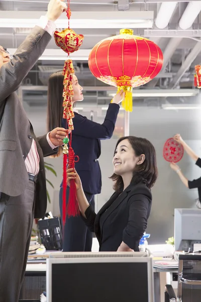 Coworkers hanging decorations for Chinese new year