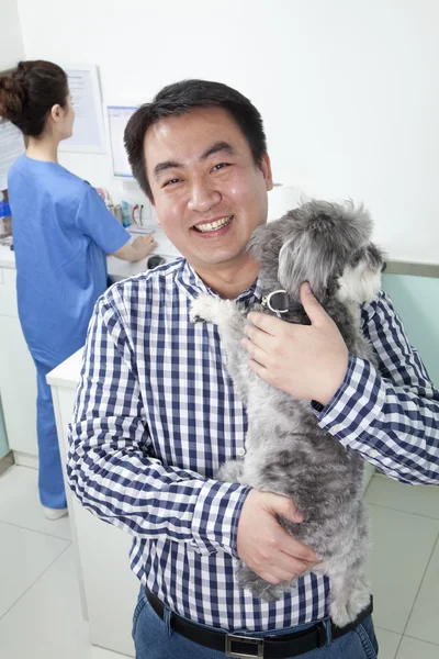 Man with pet dog in veterinarian\'s office