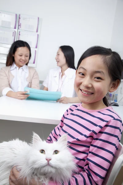 Woman and girl with pet dog in veterinarian\'s office