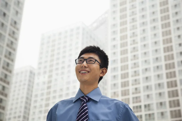 Businessman smiling and looking at the sky