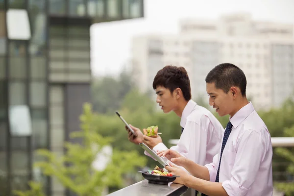 Businessmen working outdoor and eating