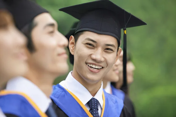 Man Smiling in a Row of Young University Graduates