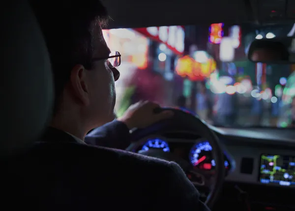 Businessman driving at night in the city