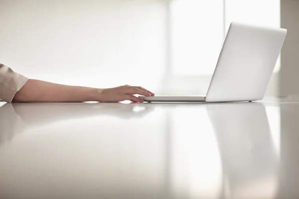Businesswoman's arm using her laptop