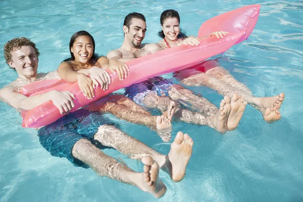 Friends in the pool with an inflatable raft