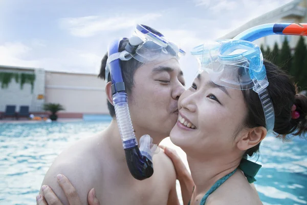 Couple kissing on the cheek in the pool