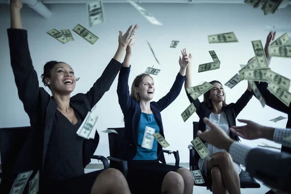 Business people with arms raised throwing money in the air