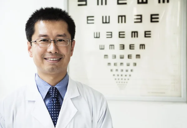 Optometrist with an eye chart in the background