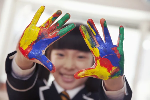 Schoolgirl finger painting, close up on hands