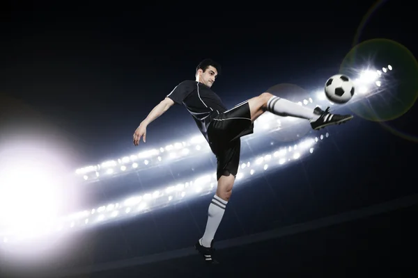Soccer player in mid air kicking the soccer ball