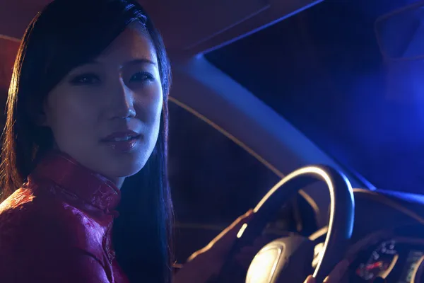 Woman in traditional clothing driving at night