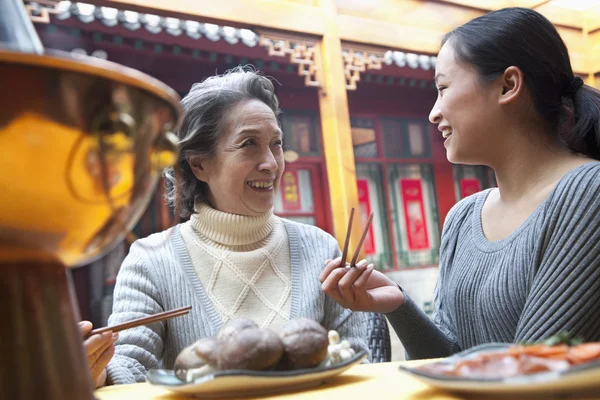 Mother and daughter enjoying traditional Chinese meal