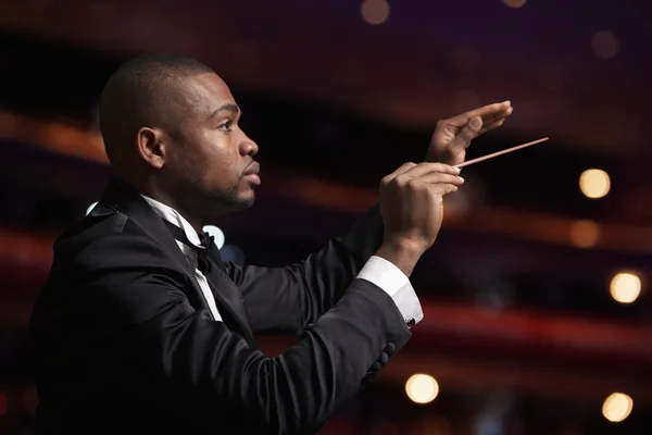 Conductor with baton raised at a performance