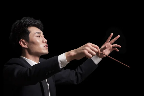 Young conductor with baton raised