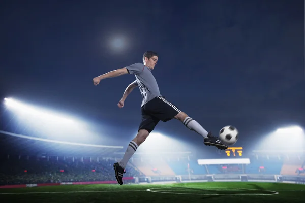 Soccer player in mid air kicking the soccer ball