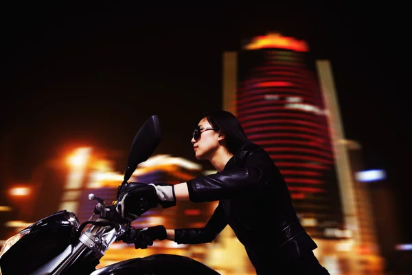 Woman riding motorcycle at night