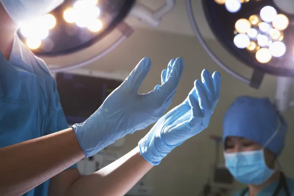 Hands in surgical gloves in the operating room