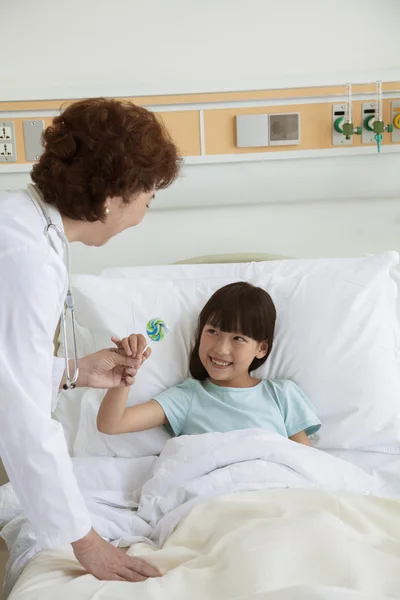 Doctor giving a lollipop to girl
