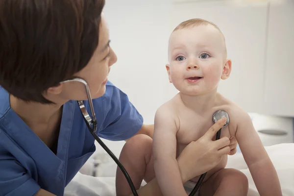 Doctor checking a baby\'s heart beat