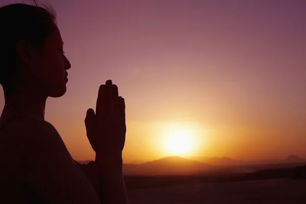 Woman with hands together in prayer pose