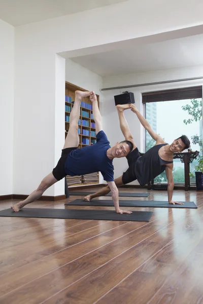 Two people doing yoga in a yoga studio