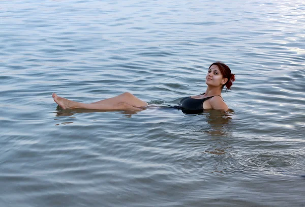 Beautiful girl floating on the Dead Sea