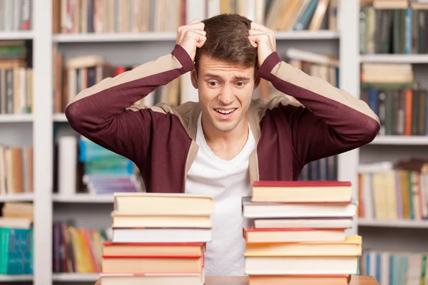 Tired young man holding his head in hands