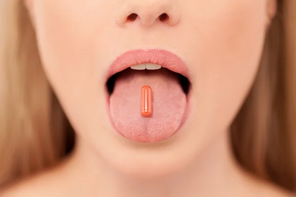 Pill on her tongue