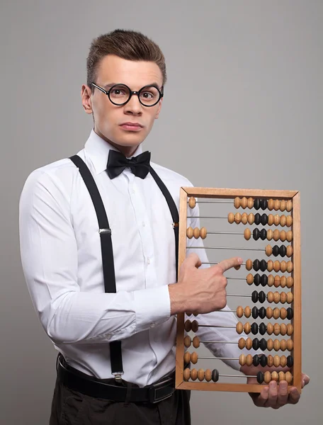 Serious young man holding abacus