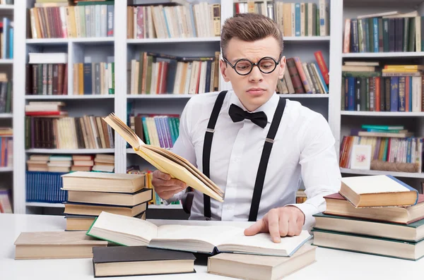 Man in shirt and bow tie reading books