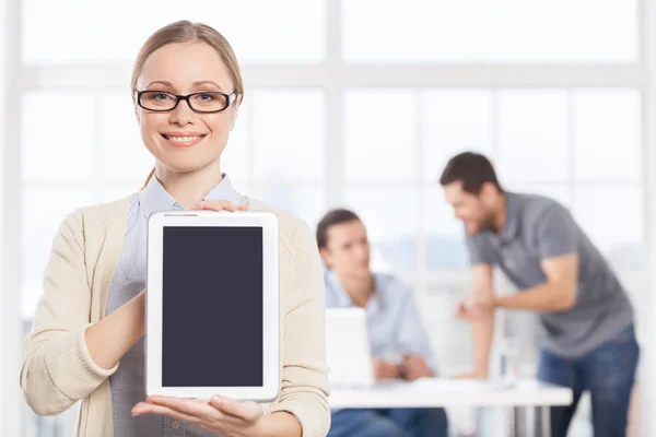 Confident young businesswoman holding digital tablet