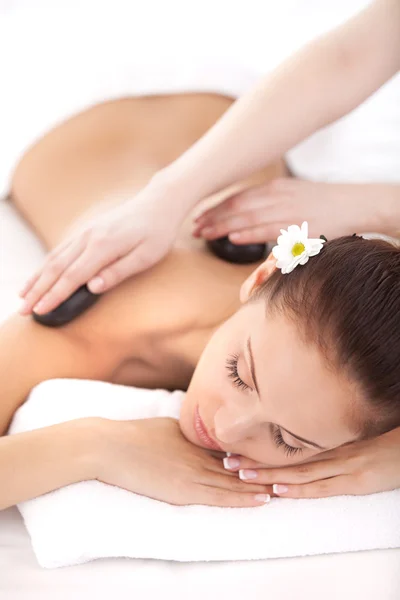 Woman lying on front while massage therapist massaging